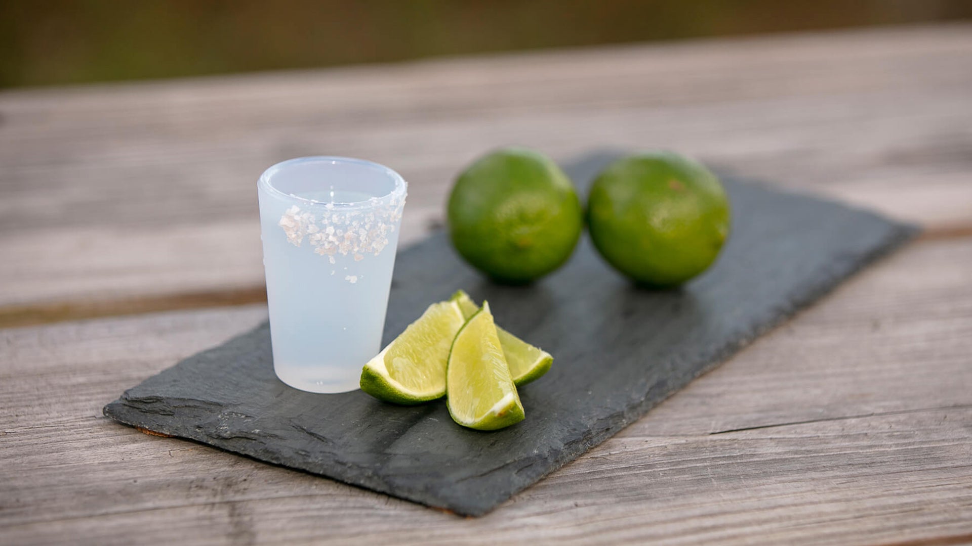 Close-up of tequila shot in a Silipint silicone shot glass with lime wedges