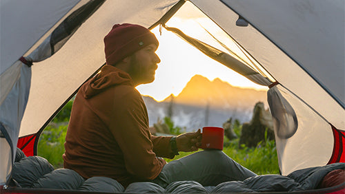 man in tent with Silipint coffee mug at sunrise