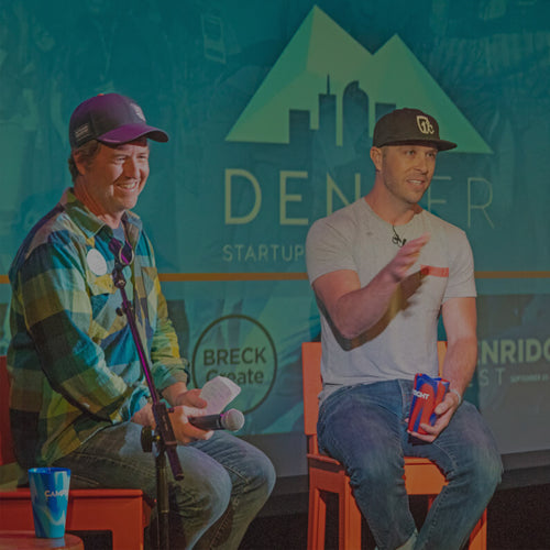 Image of two guys at a trade show on stage presenting with Silipint Cups in hand.